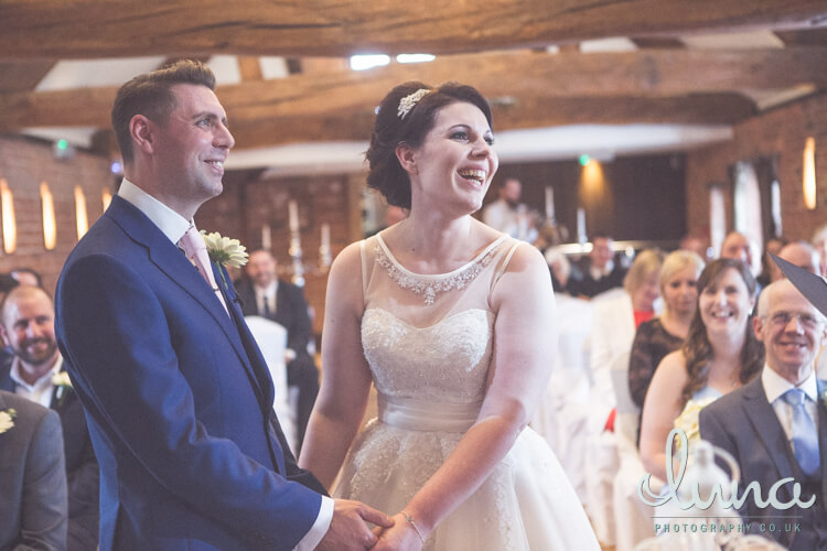 Bride and groom smiling and holding hands at Swancar Farmhouse