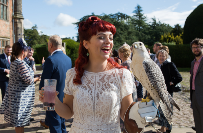 Bride with cocktail and owl in sunshine on wedding day