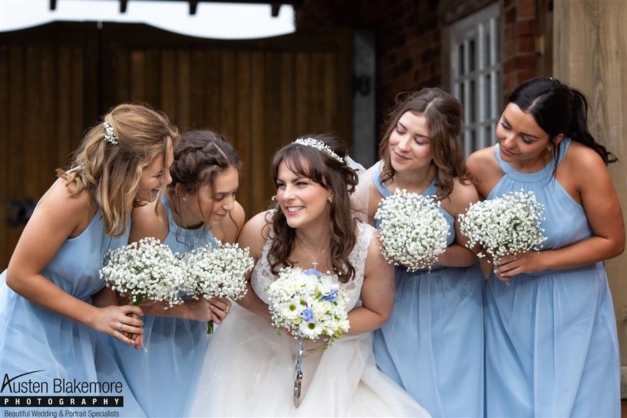 Karah and her bridesmaids all smiling with their bouquets