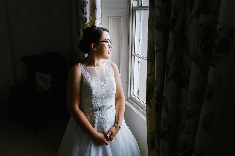 Bride looked out of a window at The Walled Garden Beeston with makeup by Ms Moo