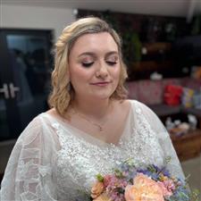 Sparkly pink eyeshadow on blonde bride with white dress with flowery applique