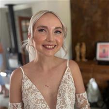 Blonde bride smiles at camera with glowing natural makeup