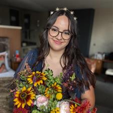 Celestial themed bride with blue dress, gold headdress and glasses smiles looking at the camera