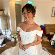 Brunette smiling bride wearing off the shoulder white dress