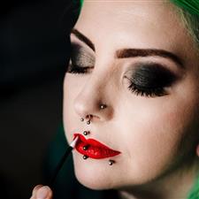 Close up of wedding client with black smoky eyes and bright red lipstick. Client has green hair and lip piercings and looks awesome!