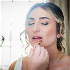 Bride with champagne eyeshadow and winged eyeliner gets lipliner applied