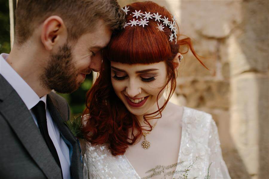 Happy couple with heads together and smiling on their wedding day