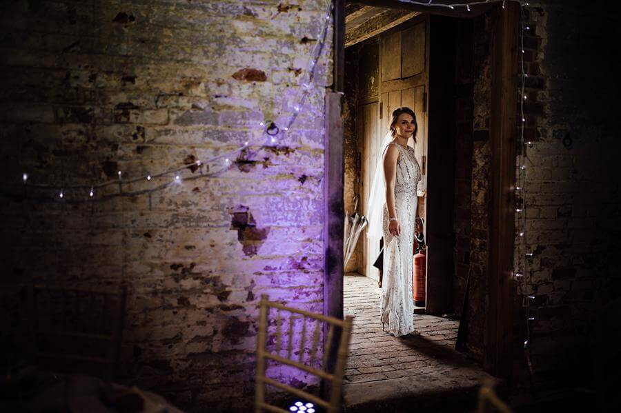 Bride portrait in stripped back room with wooden floors and rough walls