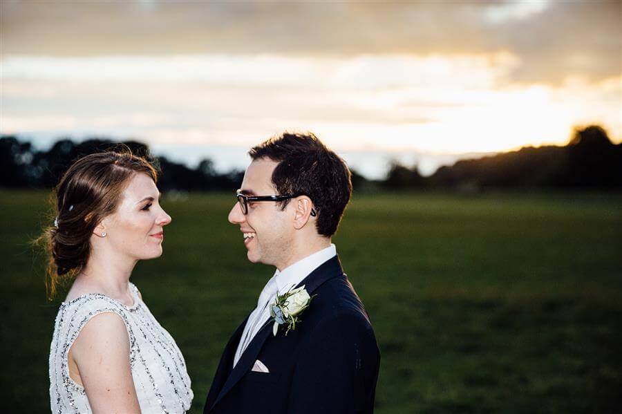 Bridal portrait in a field looking forwards a sunset