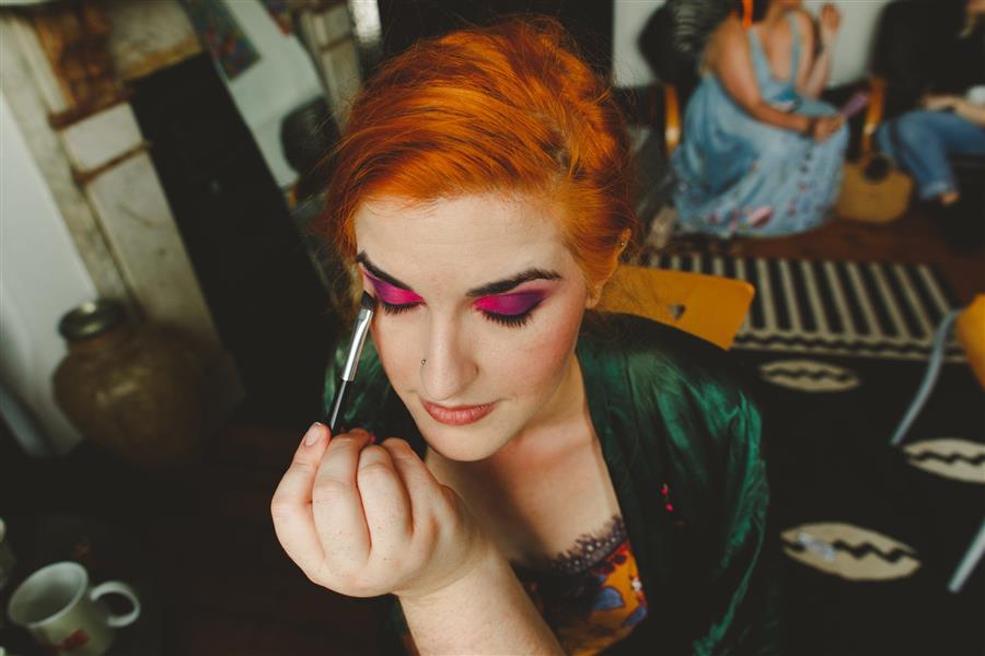 Ms Moo applying eyeliner on top of pink and purple eyeshadow