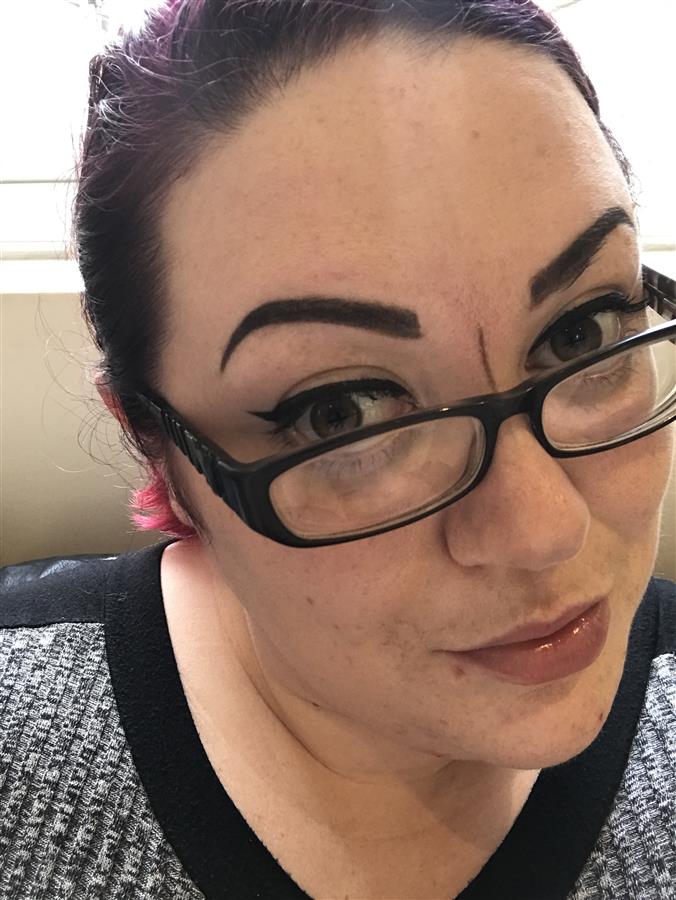 Ms Moo Make Up with drawn on eyebrows during tattooing appointment