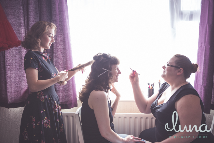 Ms Moo applies makeup to a bride to be while Lucille's Locks tongs her hair