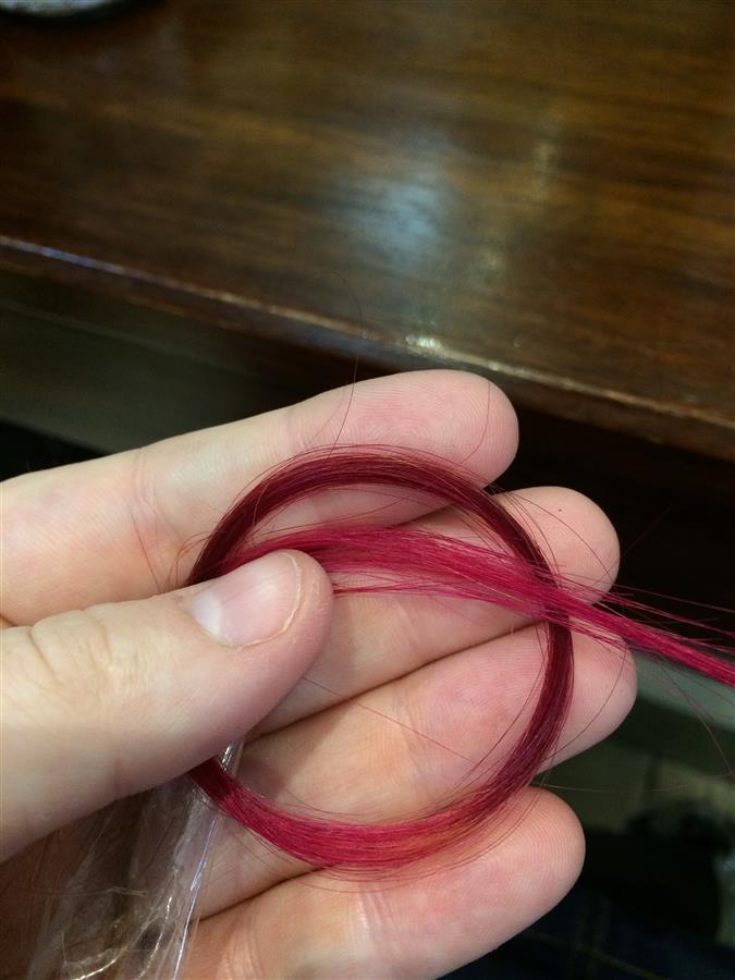 Hand holds a lock of pink and purple hair